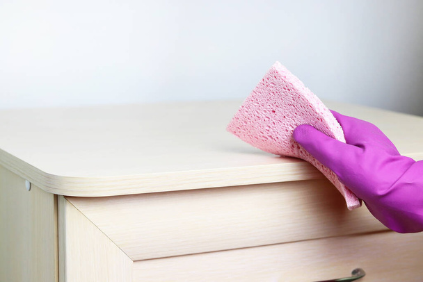 Uma mão em uma borracha, luva protetora e uma esponja rosa. Espaço de cópia - o conceito de limpeza da casa, limpeza, a destruição de bactérias
. - Foto, Imagem