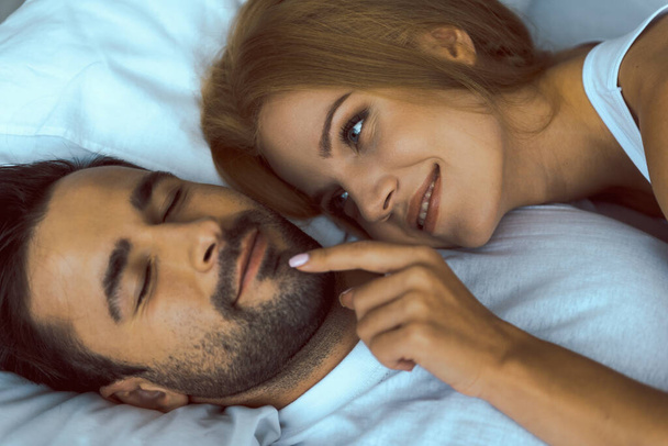 Cheerful young lady waking her boyfriend tenderly - Foto, imagen