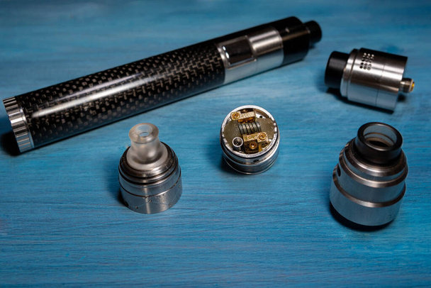 black electronic cigarette and atomizer on a blue table - Photo, Image