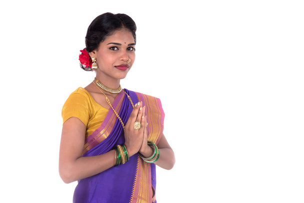 Young Indian girl in traditional clothing greeting namaste, Welcome, Indian girl in a tradition sari with welcome expression (inviting) - Foto, imagen