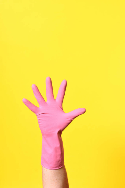 hand with glove, palm, on yellow background - Foto, Imagem