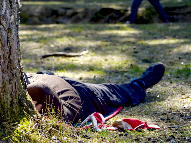 Dělník se vloupal do zahrady. Ležel v trávě. dovolená koncept. klobouk přes hlavu - Fotografie, Obrázek
