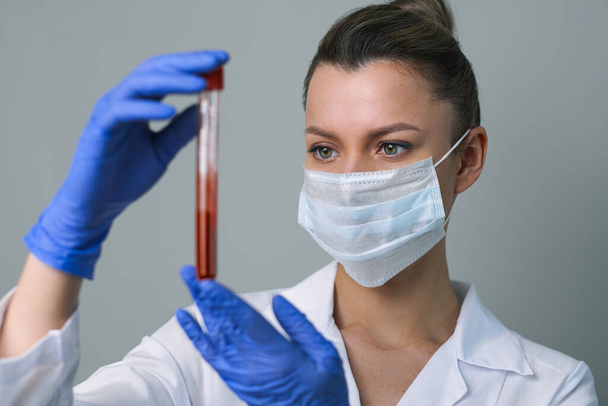 Blood test. A female medical worker holds a test tube with paciets blood. - Фото, зображення
