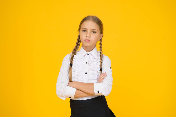 take her studies seriously. modern education concept. back to school. little girl in uniform. child after lessons. study at home. school fashion style. smart looking student yellow background - Photo, image