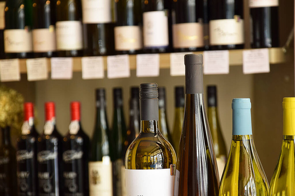 Μπουκαλάκια κρασιού σε ξύλινο ράφι στην αποθήκη κρασιού - Φωτογραφία, εικόνα