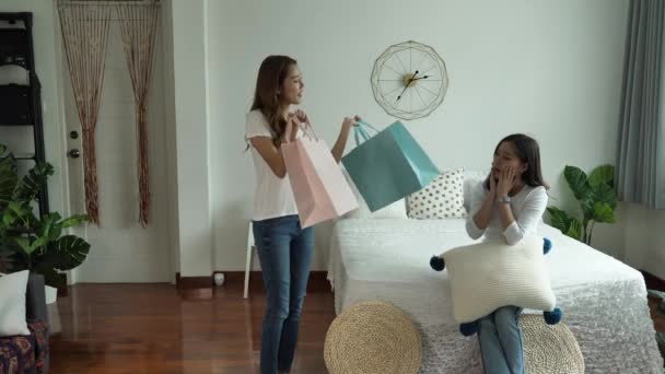 Happy Asian young woman is smiling walk returning from shopping and  holding shopping bags Show friends in bedroom at home. glad and excited about shopping.  slow motion - Metraje, vídeo