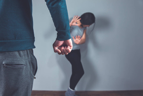 angry man fist and sad woman on grey background - Photo, Image