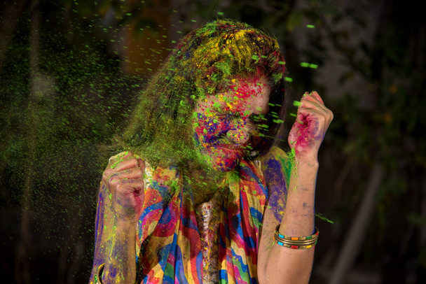 Portrait of a happy young girl with a colorful face on the occasion of Holi color festival. - Φωτογραφία, εικόνα