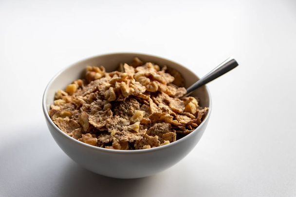 Frühstückszerealien mit gesunden Cornflakes und köstlichen Walnüssen und Honig in einer Schüssel sind der perfekte Start in den Tag und ideal für Diätlebensstil und gesunde Ernährung für Diät und Schulfrühstück - Foto, Bild