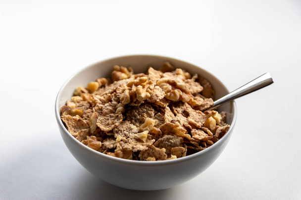 Snídaně cereálie se zdravými cornflakes a lahodné vlašské ořechy a med v misce jsou ideálním začátkem dne a jsou ideální pro dietní životní styl a zdravé jídlo pro diety a školní snídaně - Fotografie, Obrázek