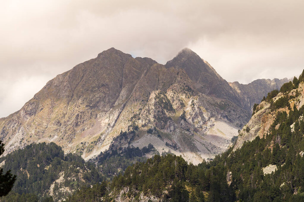 Paisaje montañoso con picos rocosos y nubes
 - Foto, Imagen