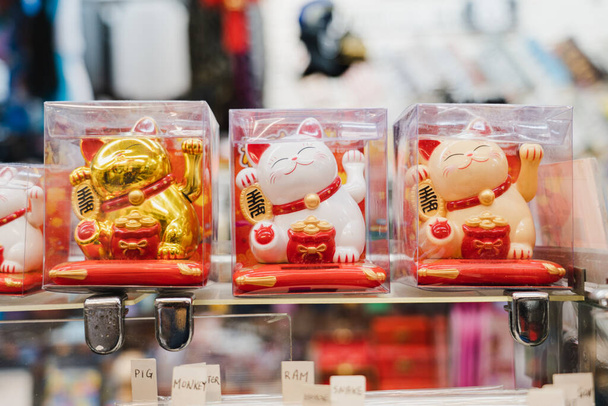 Uma variedade de gatos de boas-vindas japoneses ou gato da sorte (Maneki Neko) acreditam na grande sorte do dinheiro e do negócio em uma loja de presentes
 - Foto, Imagem