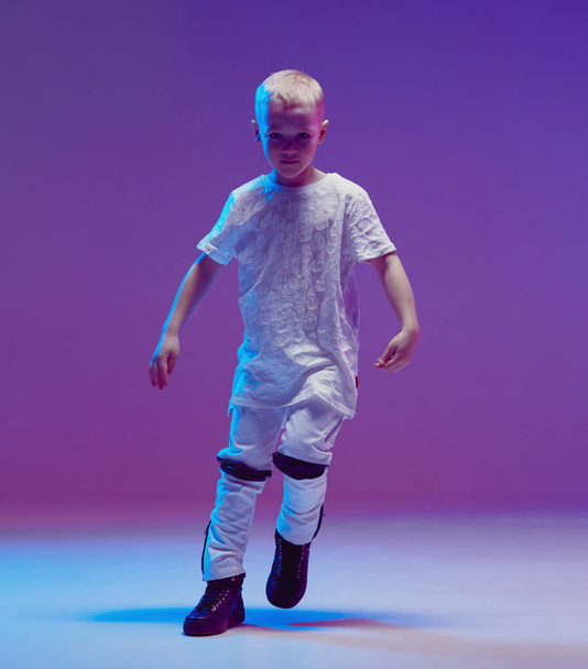 Cool young boy child dancing hip hop in the Studio against the background of neon lights. Break dance poster. - Fotografie, Obrázek