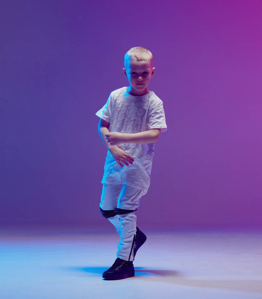 Cool young boy child dancing hip hop in the Studio against the background of neon lights. Break dance poster. - Foto, afbeelding