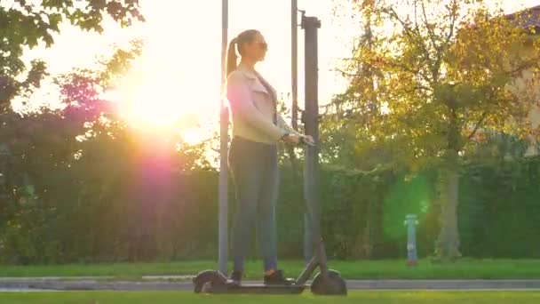 ΗΛΙΟΣ: Millennial κορίτσι βόλτες με ένα υψηλής τεχνολογίας e-scooter μέσα από τα προάστια. - Πλάνα, βίντεο