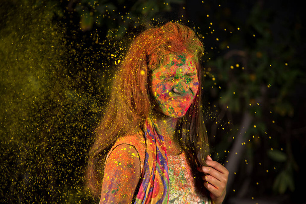 A young girl plays with colors. The concept for Indian festival Holi. color splash. - Photo, image