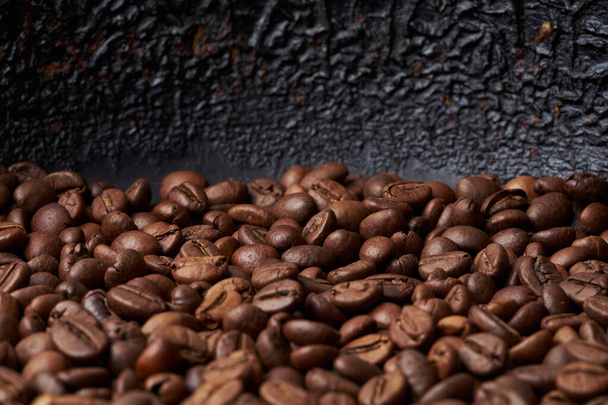 Tekstura sterty palonych brązowych całych ziaren kawy z ciemnym tle - Zdjęcie, obraz