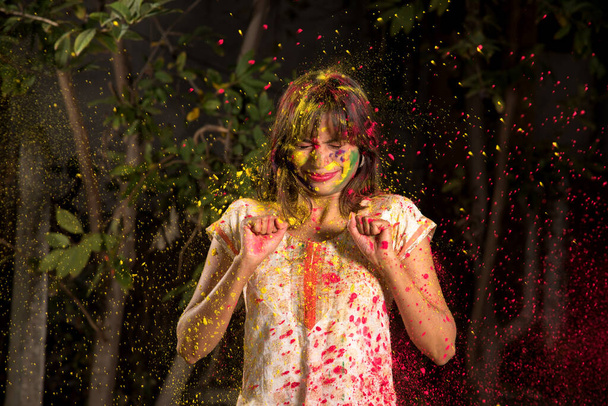 Young girl plays with colors on the occasion of Holi. Concept for Indian festival Holi. color splash. - Foto, immagini