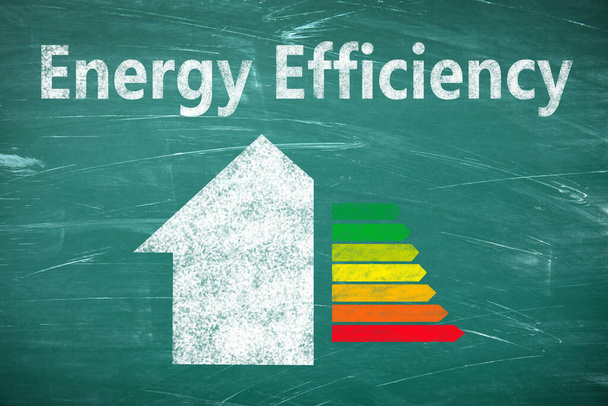 Energy efficiency concept. Part of house and colorful chart drawn on chalkboard - Foto, afbeelding