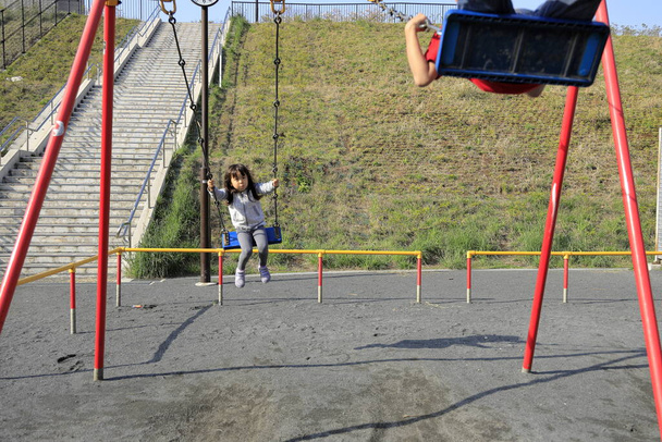 Giapponese fratello e sorella su il swing (10 anni ragazzo e 5 anni ragazza
) - Foto, immagini
