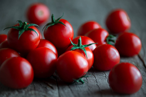 Tomates cherry orgánicos maduros frescos sobre fondo de madera oscura
 - Foto, Imagen
