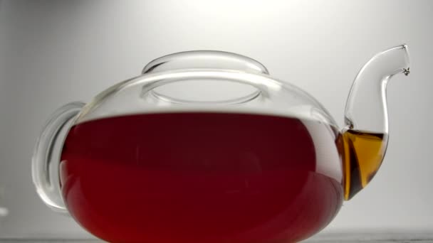 Tetera transparente con té británico marrón clásico sobre mesa de madera
 - Metraje, vídeo
