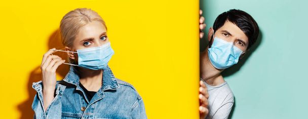 Collage of young guy and girl wearing medical face mask against coronavirus on two backgrounds of yellow and aqua menthe colors. - Valokuva, kuva
