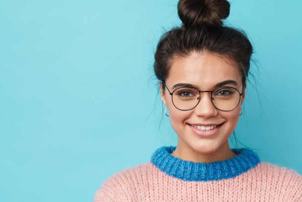 Image of cheerful beautiful woman in eyeglasses smiling and looking at camera isolated over blue background - Fotografie, Obrázek