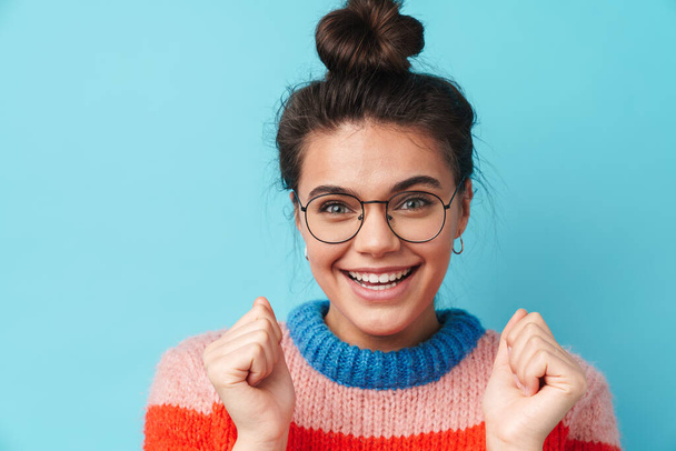 Image of happy beautiful woman in eyeglasses smiling and looking at camera isolated over blue background - Фото, изображение
