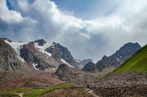 氷河の雪と高い岩の山々の風景帽をかぶったピークと人々は、この美しさを見て - 写真・画像