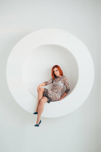 red-haired model girl with blue eyes on a white circle background - 写真・画像