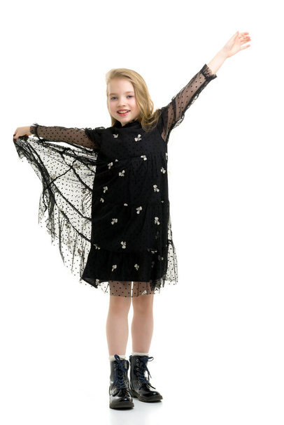 A little girl holds her hands on the edges of the skirt. - Fotografie, Obrázek
