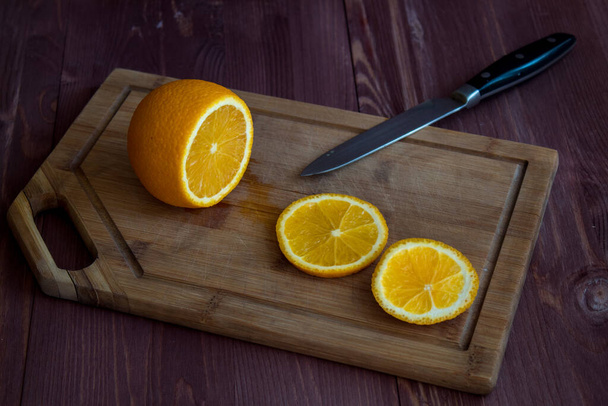orange and knife on a wooden board. cut orange - Photo, Image