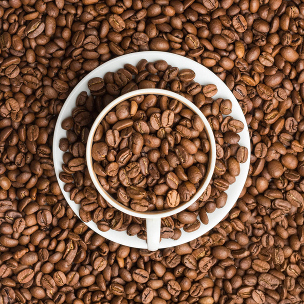 La taza de café y el platillo están llenos de granos de café y rese
 - Foto, Imagen