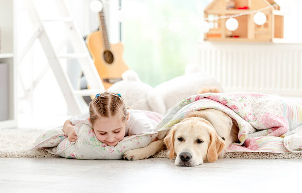 Little girl with dog under blanket - 写真・画像