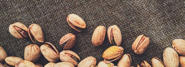 Pistachio nuts on rustic linen background - Photo, image
