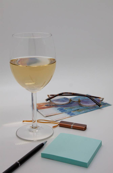  A pair of one hundred franc Swiss banknotes, a glass of wine, a pen, stickers, glasses, a flash drive, copywriting, earnings at home, a successful order - Valokuva, kuva