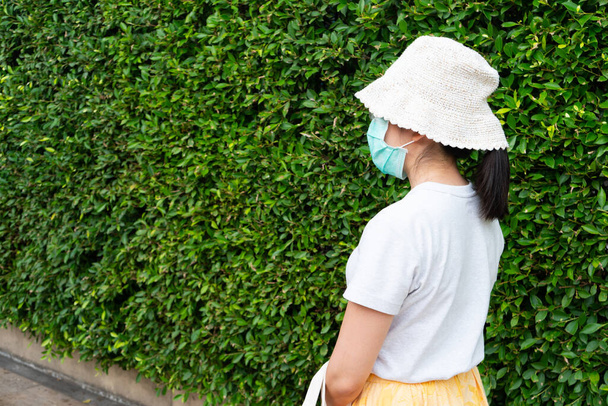 young asian woman wearing surgical face mask before going out to shopping to prevent covid-19 or coronavirus infection and pm 2.5. new normal lifestyle - Photo, Image
