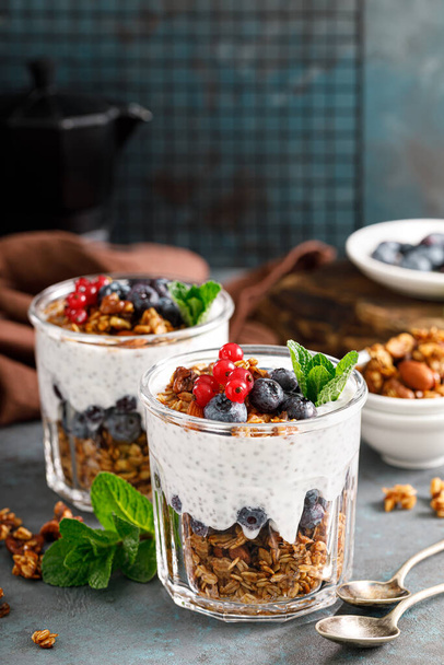 Layered blueberry and red currant parfait with chia yogurt, homemade oat granola and fresh berries for breakfast - Photo, Image