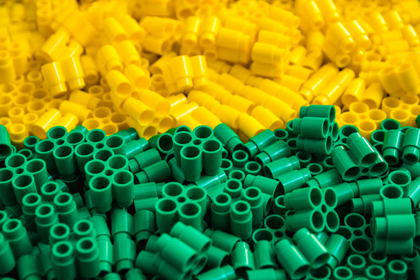 Πλαστικά τούβλα από κίτρινο και πράσινο. Λεπτομέρειες παιχνιδιών. Κλείσε.. - Φωτογραφία, εικόνα