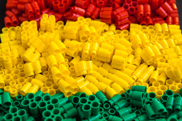 Ladrillos de plástico de color rojo, amarillo y verde. Detalles de los juguetes. De cerca.
. - Foto, imagen