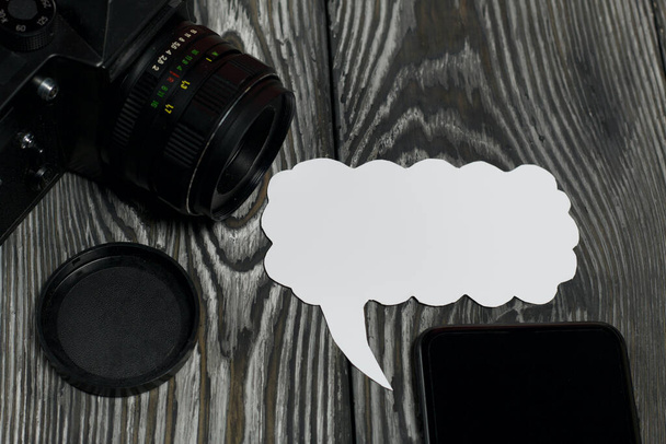 Blogger camera and smartphone. Near the speech bubble. Against the background of brushed pine boards. - Foto, imagen