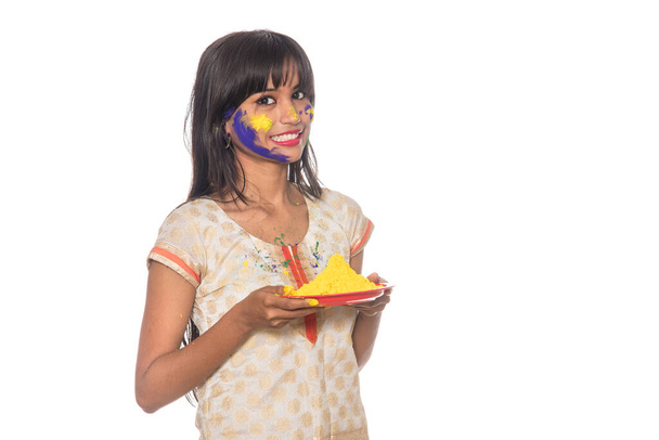 Beautiful young girl holding powdered color in plate on the occasion of Holi festival. - 写真・画像