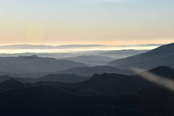 primeros rayos de sol con niebla en los valles montañosos
 - Foto, imagen