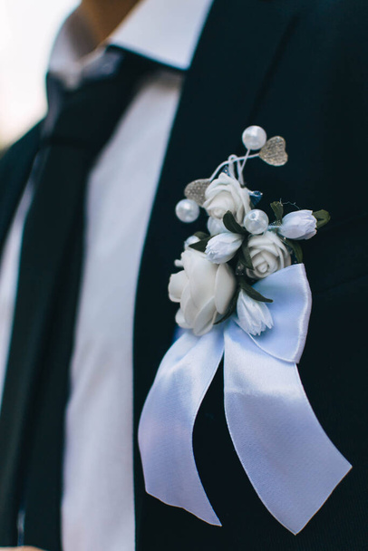 Esküvői boutonniere egy fekete szmokingban a vőlegény. - Fotó, kép