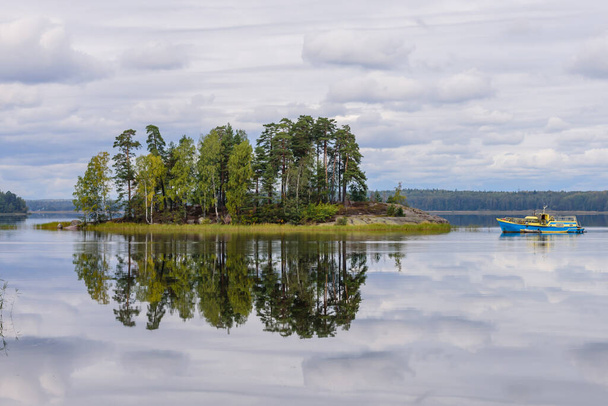 Malownicze jezioro z wyspą. Zwiedzanie Vyborg, obwód leningradzki, Rosja. Monrepo Park jest malowniczym parkiem przyrody w Vyborgu. Piękny widok jesieni - Zdjęcie, obraz