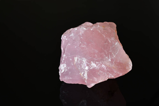 Una imagen de un cristal de cuarzo rosa sin cortar sobre un fondo negro
.  - Foto, Imagen