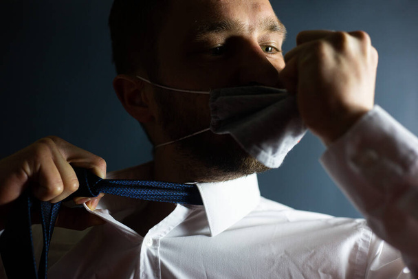 Een man doet zijn gezichtsmasker af Stop het coronavirus met emoties, COVID-19 - Foto, afbeelding