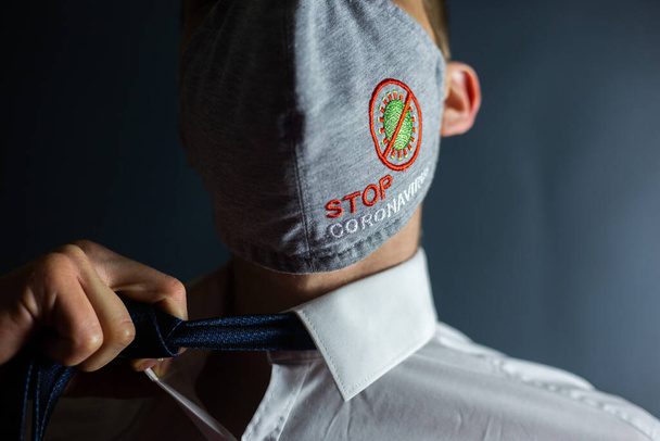 Άντρας με γραβάτα και μάσκα "Σταματήστε τον ιό Coronavirus" - Φωτογραφία, εικόνα