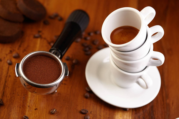 чашки еспресо кави, складені на дерев'яному столі з квасолею
 - Фото, зображення